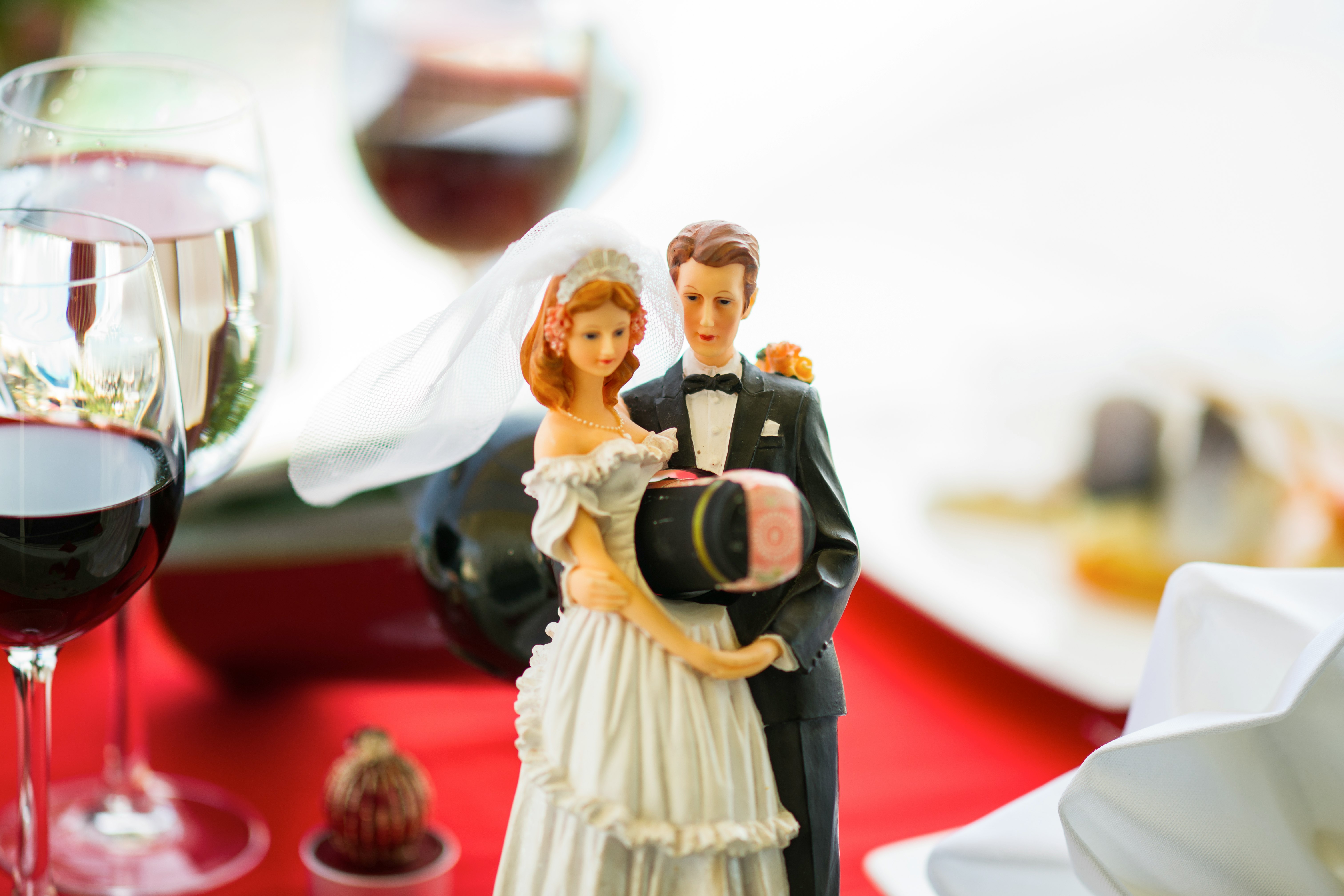 woman in white dress holding man in black suit figurine